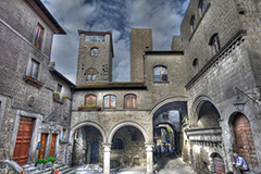 Scorcio della piazza con il portico, il palazzo degli Alessandri e la torre Scacciaricci